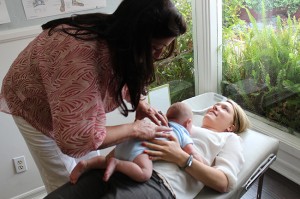 Dr. Kerry Keiser performs a newborn spinal adjustment, which can alleviate many postpartum ailments.