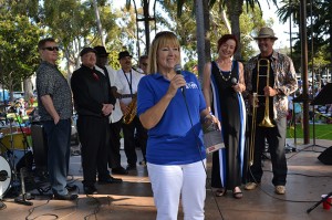 Cathy Brown, president of Coronado Promenade Concerts, introduces a local favorite band, Cool Fever.