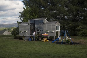 This 172-square-foot tiny house on wheels was built for a couple and their three-year-old daughter. A full-size kitchen occupies the center portion; the master bedroom is to the right, and a child’s bed with play loft and bath/shower is to the left.