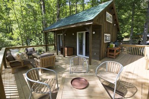 A large wraparound deck offers plenty of outdoor entertaining and relaxation space at this river cabin, the abode of a family (two adults and a teenage son and daughter) who operate a river-rafting business.