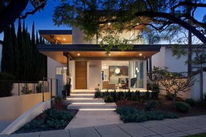 The Cajon home’s exterior is accented with mahogany cladding, with uplighting providing a warm evening glow.